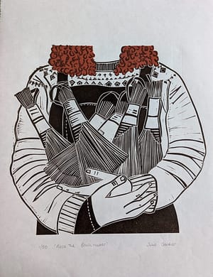 Lino print of a girl with curly red hair holding some brushes she has made.