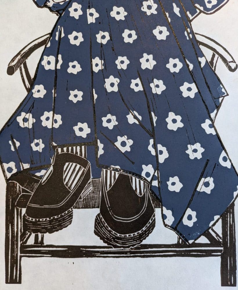 Lino print of a dreaming girl wearing a blue daisy print dress
